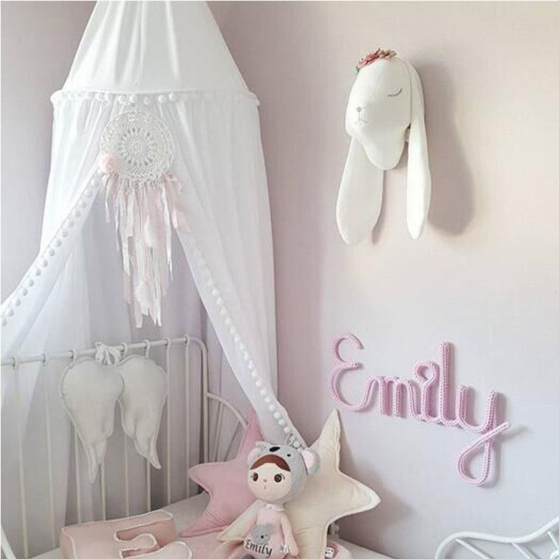 Kinderzimmer-Dekoration mit Pompon-Baldachin und Moskitonetz