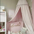 Kinderzimmer-Dekoration mit Pompon-Baldachin und Moskitonetz